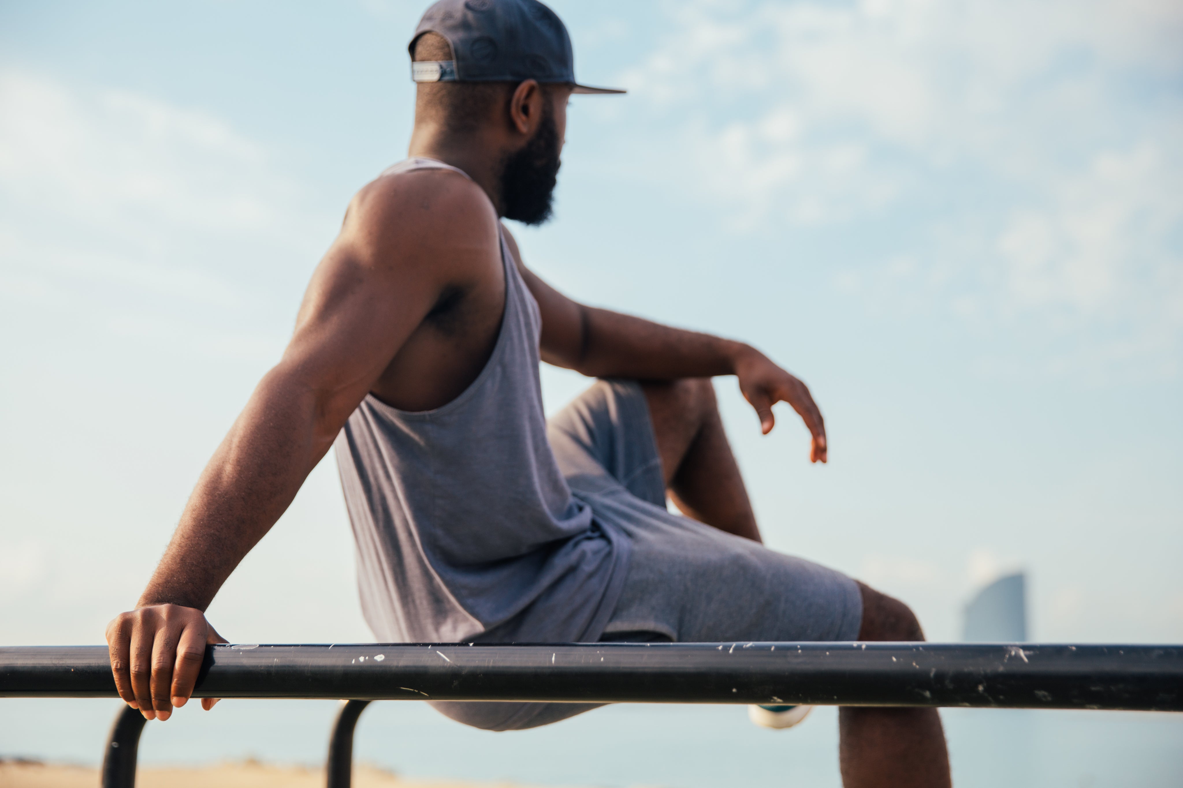 man relaxing at the beach after a work out